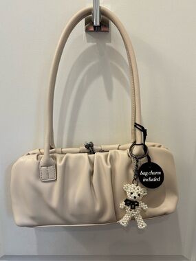 NWT BCBG Creamy beige baguette bag with pearly bear bag charm